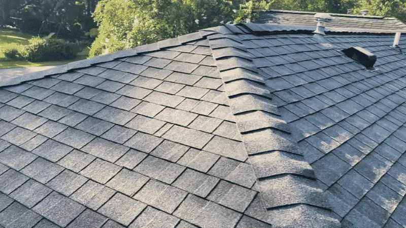A clean gray architectural shingle roof with ridge caps after a professional roof cleaning service.