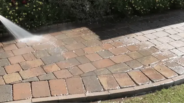 Pressure washing a curved brick paver walkway to remove dirt during sidewalk cleaning in Wilmington, NC