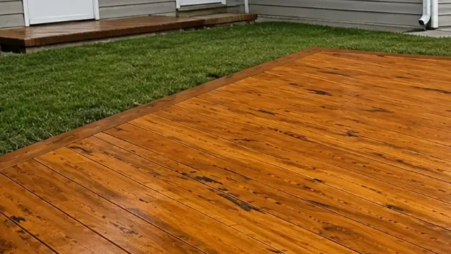 Freshly cleaned cedar wood deck with rich orange color beside a green lawn - Deck Cleaning in Wilmington, NC