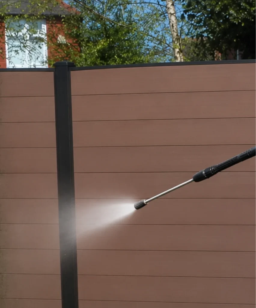 Composite Privacy Fence Pressure Washing - Fence Cleaning Wilmington, NC Pressure washer wand cleaning a brown composite privacy fence