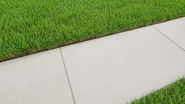 Bright clean concrete sidewalk running between green lawns - Sidewalk Cleaning Wilmington, NC