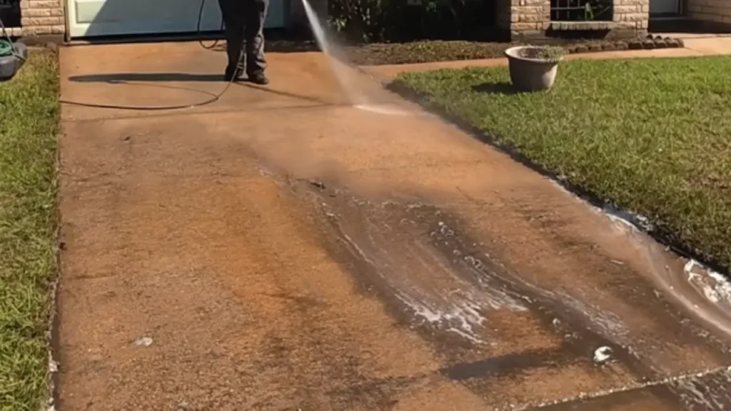 Driveway Pressure Washing Red Clay Stains - Driveway Cleaning Wilmington, NC Technician pressure washing red clay stains off a concrete driveway