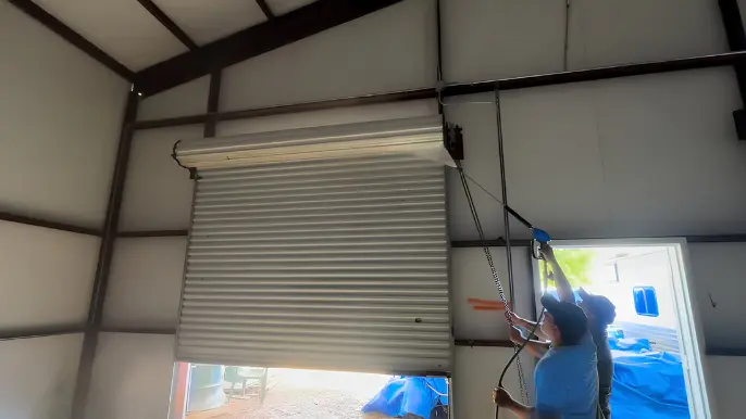 Garage Roll Up Door Pressure Washing - Professional Pressure Washing Wilmington, NC Technician pressure washing a roll-up door inside a metal building - Professional Pressure Washing Wilmington, NC