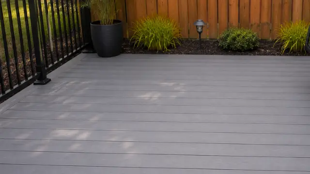 Clean gray composite deck with black metal railing and potted plants - Deck Cleaning in Wilmington, NC