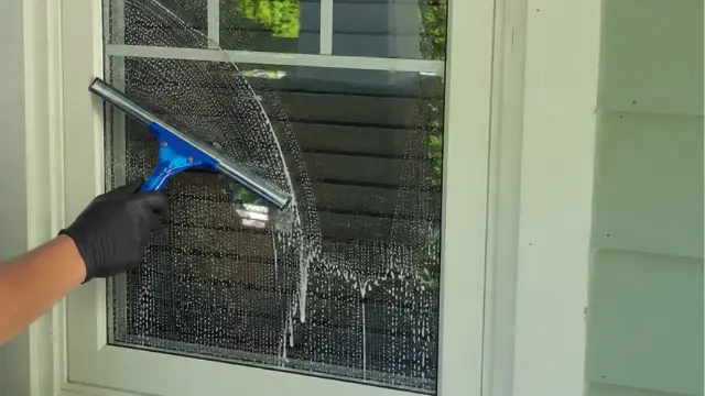 Residential Window Squeegee Cleaning - Window Cleaning Wilmington, NC Gloved hand squeegeeing a soapy residential window - Window Cleaning Wilmington, NC