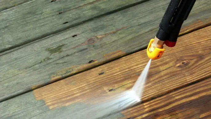 Wood Deck Pressure Washing Close Up - Professional Pressure Washing Wilmington, NC Close-up of a pressure washer nozzle stripping grime from wood deck boards - Professional Pressure Washing Wilmington, NC