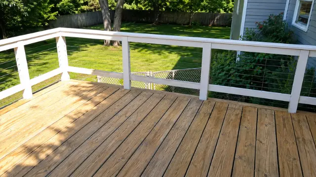 Clean natural wood deck with white railing overlooking a backyard - Deck Cleaning in Wilmington, NC